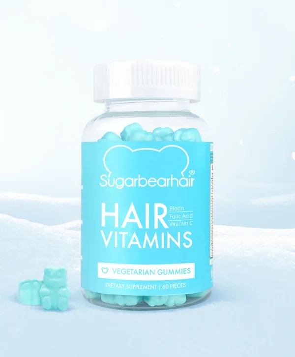 Une bouteille de vitamines capillaires SugarBearHair entourée de neige.