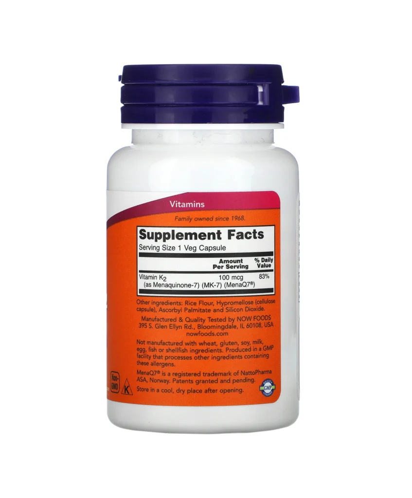 Une bouteille blanche de vitamine K-2 MK-7 de NOW Foods avec un bouchon violet, comportant une étiquette qui affiche les informations et les ingrédients du supplément, mettant l'accent sur la vitamine K2 MK-7 pour une absorption et un soutien optimaux.