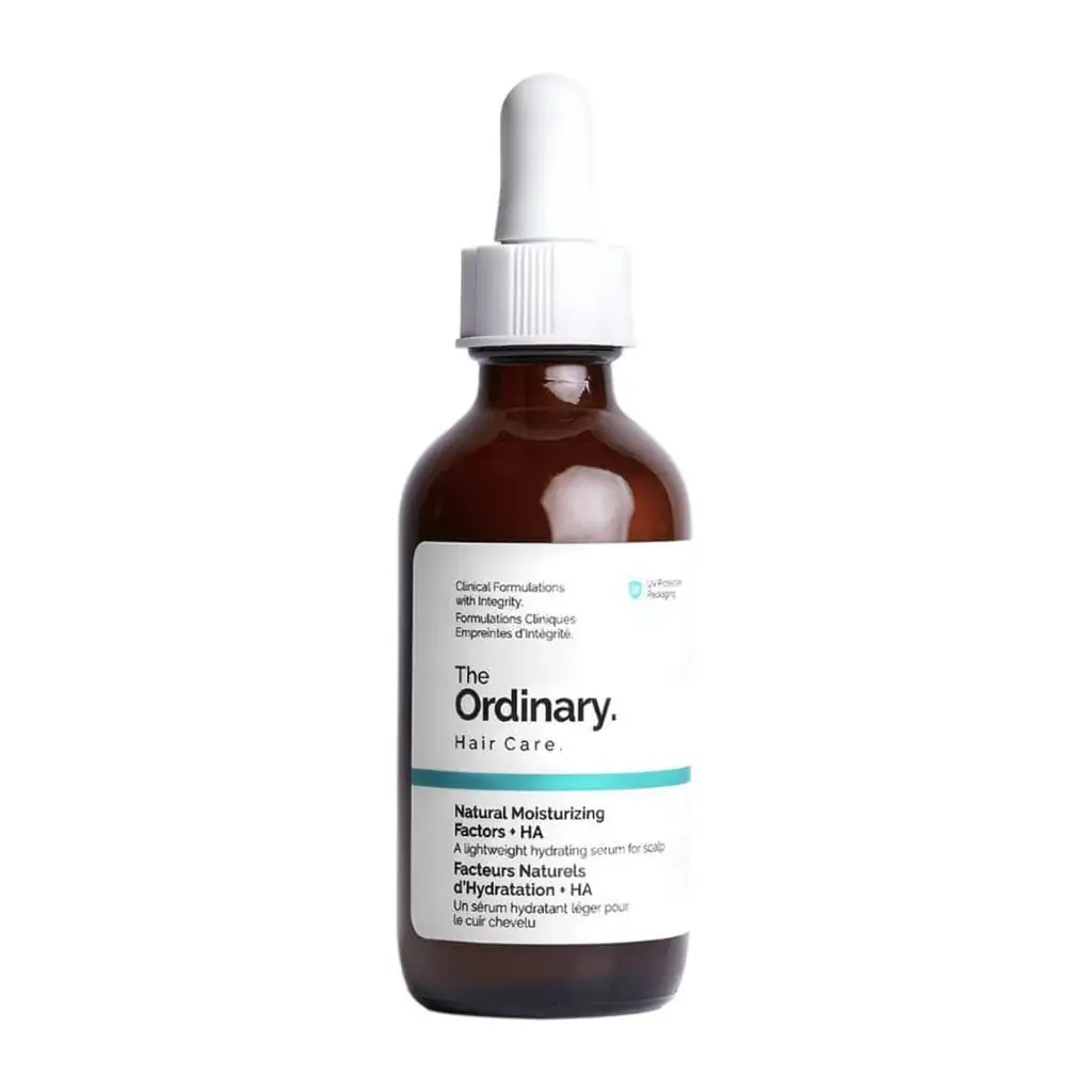 Un flacon compte-gouttes marron étiqueté "The Ordinary NMF + HA Sérum Cuir Chevelu - Hydratation & Squalane | 60 ml" avec un bouchon blanc, idéal pour l'hydratation du cuir chevelu.